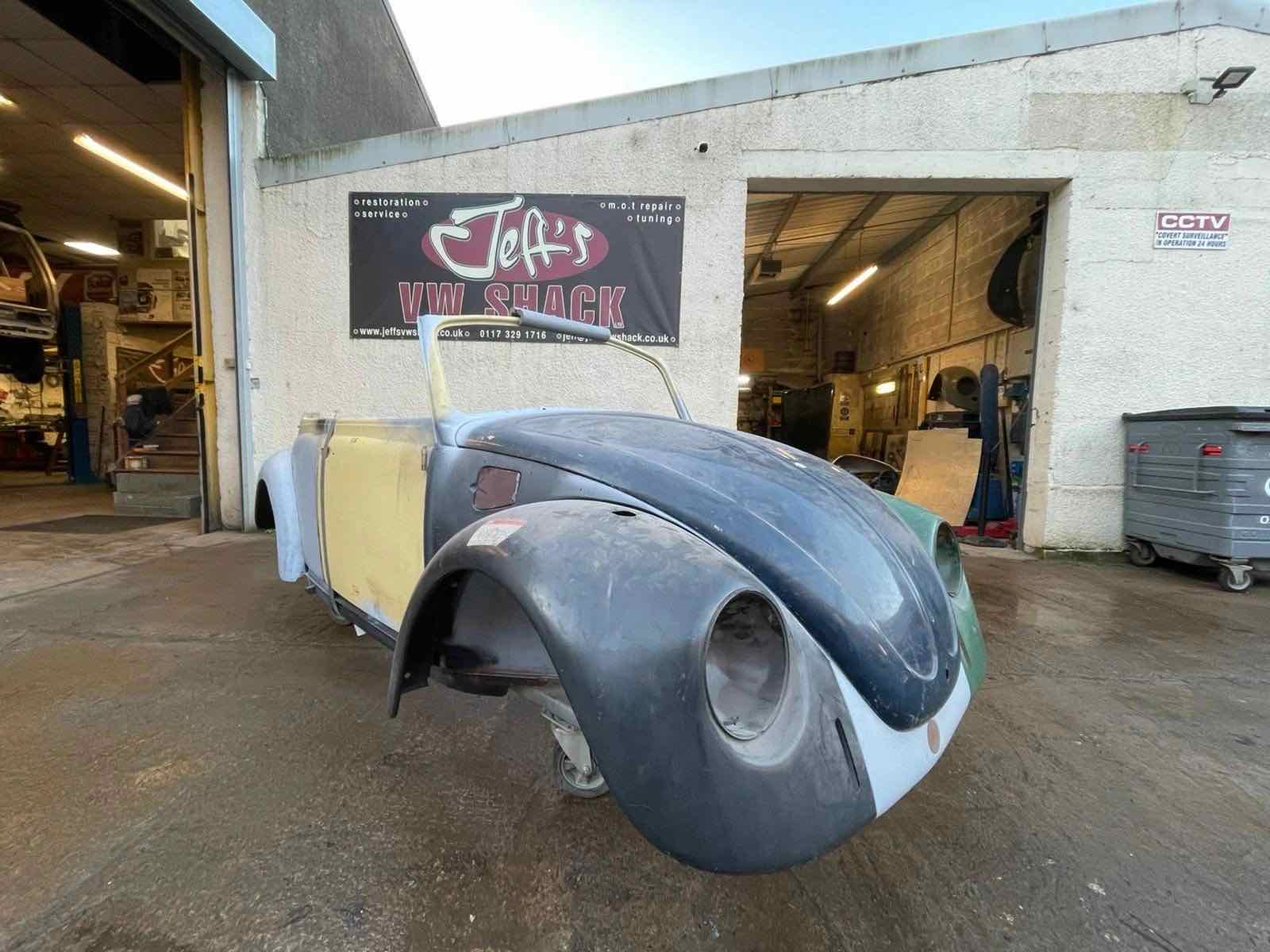 A Beetle cabriolet shell outside the workshop under the Jeff's VW Shack banner