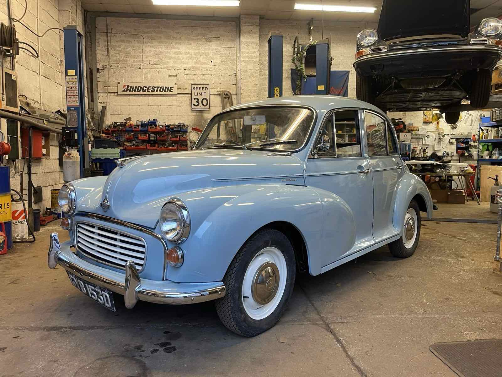 A pale blue Morris Minor saloon, polished, in the workshop