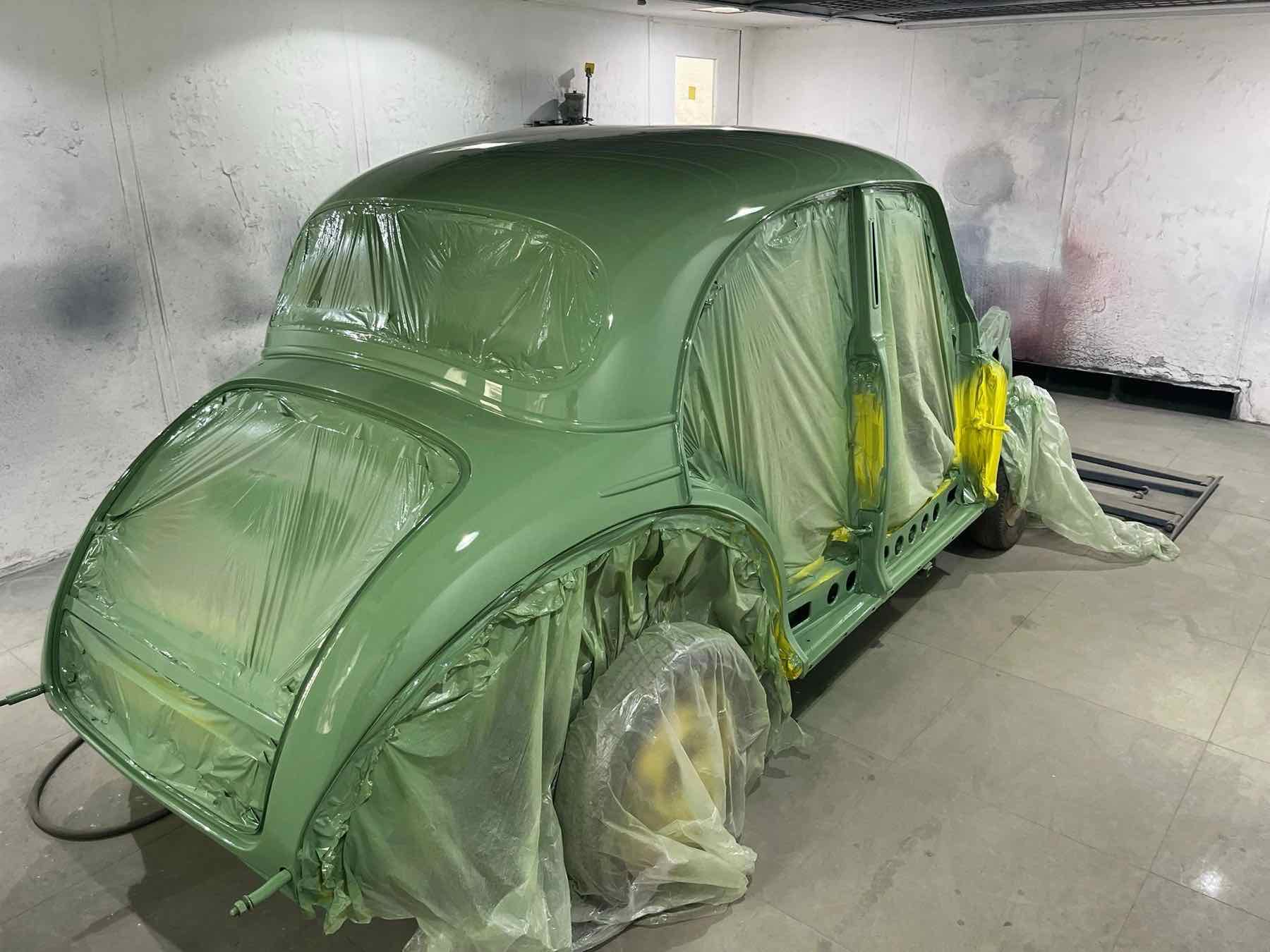 A Morris Minor in fresh green paint in the spray booth
